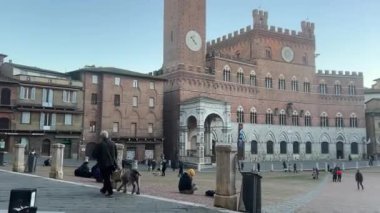 Siena, İtalya - 23 Aralık 2024: Bustling Piazza del Campo, Siena 'nın tarihi merkezi. Siena 'daki Pubblico Sarayı..