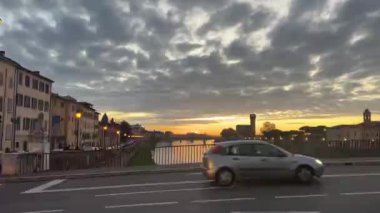 Pisa, İtalya - 27 Kasım 2024: Pisa 'daki Arno Nehri' nin manzaralı günbatımı manzarası, tarihi binalar ve yakınlardaki köprülerin manzaralı nehir kenarına eklenmesi.