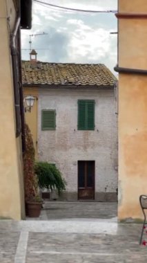 Monteriggioni, Tuscany 'deki tuhaf bir İtalyan restoranında sıcak bir kolye cephesi, kırsal ahşap kapılar ve ortaçağ cazibesi uyandıran büyüleyici bir dış mekan dekoru var..