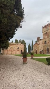 Trequanda, İtalya - 25 Kasım 2024: Tuscany 'de 13. yüzyıl ortaçağ şatosu olan büyüleyici tarihi bir binanın bölgesi, şimdi ise bir otel. Kırsal taş duvarlar, kemerli pencereler.