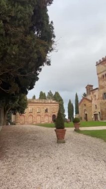 Trequanda, İtalya - 25 Kasım 2024: Tuscany 'de 13. yüzyıl ortaçağ şatosu olan büyüleyici tarihi bir binanın bölgesi, şimdi ise bir otel. Kırsal taş duvarlar, kemerli pencereler.