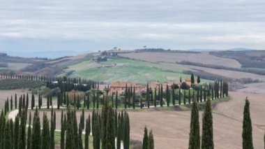 Tuscany 'deki Agriturismo Baccoleno çiftliğinin manzarası. Arka planda Val d 'Orcia tepeleri olan Asciano' daki selvi ağaçları ve beyaz çakıl yolu olan en ünlü yerlerden biri..