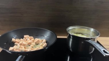 Makarna için tavada somon pişirirken, makarna ocakta haşlanıyor. Basit ve lezzetli bir ev yapımı yemek..