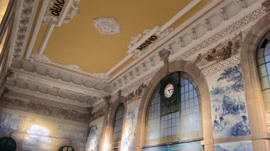 Porto, Portekiz - 25 Şubat 2025: Porto 'daki Sao Bento tren istasyonu. Büyük azulejo fayans duvarları, yüksek tavanlar, kemerli pencereler ve gezginlerle dolu tarihi bir salon.. 