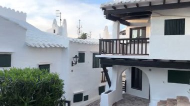 Geleneksel beyazlatılmış binibeca Vell, Menorca evleri, panjurları ve mavi gökyüzünün altında ahşap balkonları var. Huzurlu mimarisi olan büyüleyici bir Akdeniz köyü..