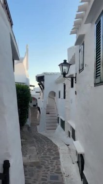 Geleneksel beyazlatılmış binibeca Vell, Menorca evleri, panjurları ve mavi gökyüzünün altında ahşap balkonları var. Huzurlu mimarisi olan büyüleyici bir Akdeniz köyü..