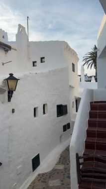 Geleneksel beyazlatılmış binibeca Vell, Menorca evleri, panjurları ve mavi gökyüzünün altında ahşap balkonları var. Huzurlu mimarisi olan büyüleyici bir Akdeniz köyü..