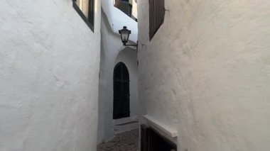 Geleneksel beyazlatılmış binibeca Vell, Menorca evleri, panjurları ve mavi gökyüzünün altında ahşap balkonları var. Huzurlu mimarisi olan büyüleyici bir Akdeniz köyü..