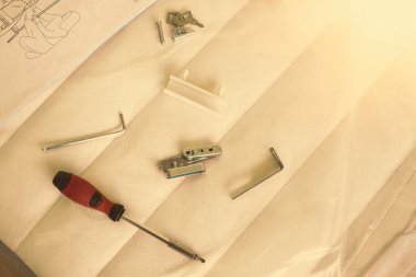 Parts and tools for self assembly furniture lying on mattress. High quality photo