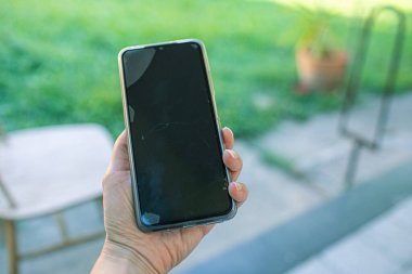 Bahçede cep telefonu tutan kadınların elini kapatıyoruz. Yüksek kalite fotoğraf