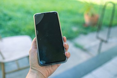 Bahçede cep telefonu tutan kadınların elini kapatıyoruz. Yüksek kalite fotoğraf