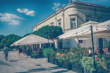 Szekesfehervar, Macaristan - 9 Temmuz 2024: Güneşli bir yaz gününde şehir merkezi cadı kafeleri. Yüksek kalite fotoğraf
