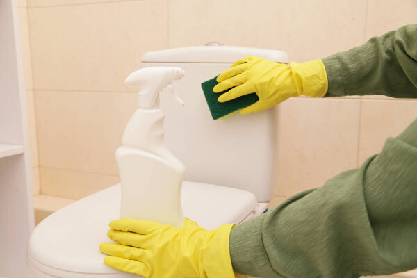 Mockup for Bottle of Cleaning Agent for Toilet disinfection, Close-up. Hands Women Wearing Protect Glove Yellow using liquid Cleaning Toilet, Disinfection Hygiene Eco Concept