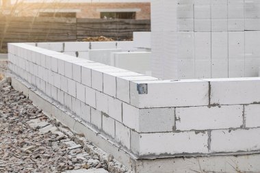 Havalı Beton İnşaatı. Beyaz havalandırmalı beton bloklardan yapılma tamamlanmamış ev duvarı