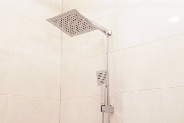 Bej banyoda modern kare krom duş başlığı, Sessiz Lüks. Banyo 'da Bej Seramik Duvar Döşemeleri