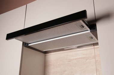 Modern Range Hood. Aşçı Başlıklı. Modern iç mekan bej rengi ve ev aletleri olan mutfak. Evde yemek pişirmek.