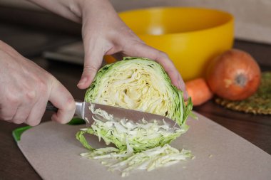 Sağlıklı salata hazırlayan kadın ellerini kapat. Ev Mutfağı tezgahında Genç Lahana Kesme Kurulu.
