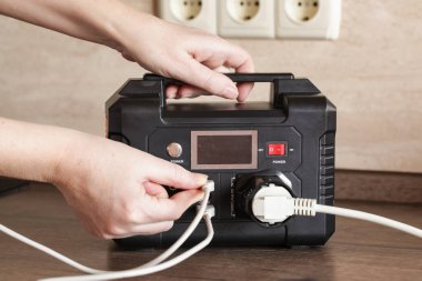 Taşınabilir elektrik santrali ve içinde şarj cihazları olan çoklu soket eklenti.