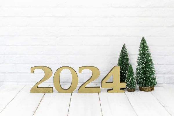 2024 Yeni Yıl ve Noel ağacı beyaz arka planda beyaz ahşap masa üzerinde boş alan ile