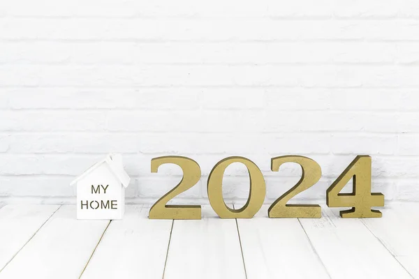 2024 コピースペース 不動産の概念が付いている白い背景上の白い木製のテーブルの新しい年そして家 ストック画像