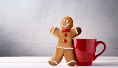 Neşeli Zencefilli Kurabiye Adam Sıcak Kış Titreşimleri İçin Kırmızı Kupaya Yaslanıyor