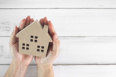 Güvenli Cennet: Ev ve Güvenliği Sembolize eden Elleri Tahta Ev Modeli