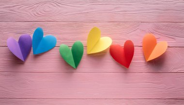 Aşk Kutlaması için Pembe Tahta Arkaplan Renkli Kağıt Kalpler Düzenleme