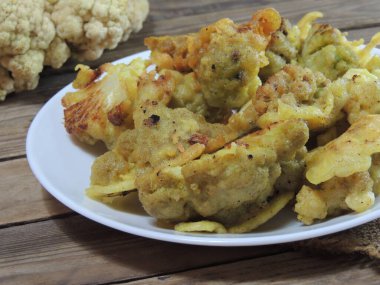 Ahşap arka planda kızarmış tavuk ve sebze.