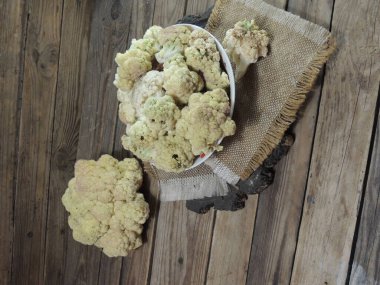 Tahtadaki ahşap kasede çiğ beyaz karnabahar.