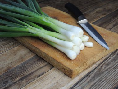 Bir ahşap tahta üzerinde taze yeşil soğan