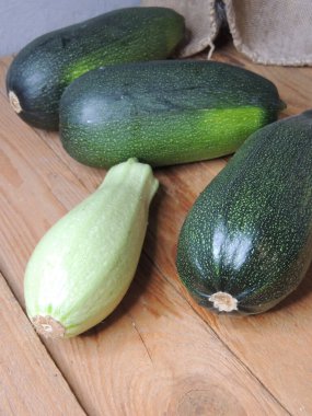 Aşçı ev mutfağında ahşap tahtada kabak kesiyor.