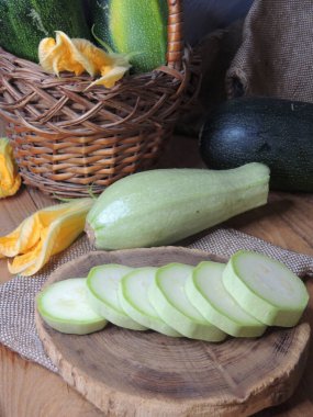 Aşçı ev mutfağında ahşap tahtada kabak kesiyor.