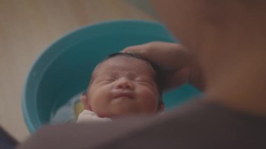 Annenin bebeğin saçında banyo yaptığı eli yavaş çekimde kapat.