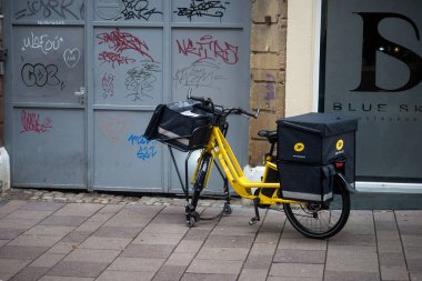 Strasbourg - Fransa - 19 Kasım 2022 - Caddeye park edilmiş sarı Fransız posta bisikletinin görüntüsü