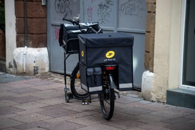 Strasbourg - Fransa - 19 Kasım 2022 - Caddeye park edilmiş sarı Fransız posta bisikletinin görüntüsü