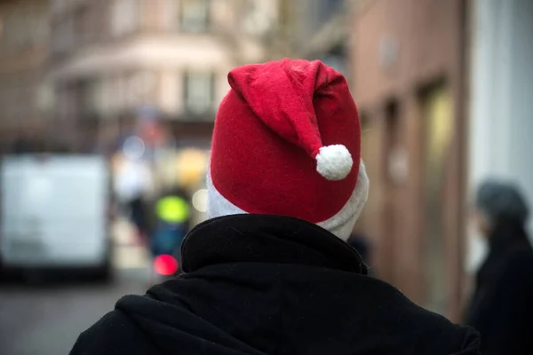 ストリートでクリスマスの帽子をかぶった男の背中のビューの肖像画 — ストック写真