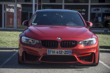 Lutterbach - Fransa - 4 Eylül 2022 - Caddeye park edilmiş kırmızı bmw M3 'ün ön görüntüsü
