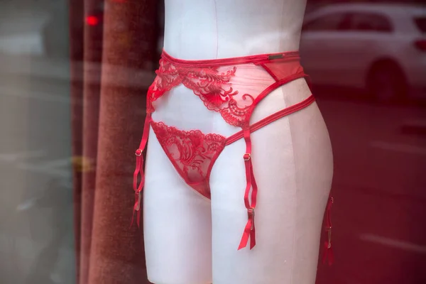 Closeup of redsuspended belt on mannequin in  a fashion store showroom