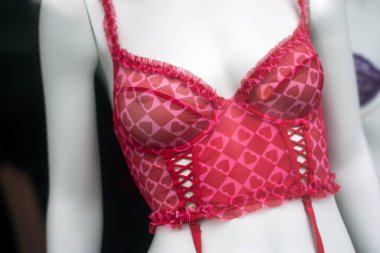 Moda mağazasının vitrininde küçük kalpleri olan kırmızı sutyenin yakın çekimi. 