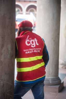 Mulhouse - France - 7 February 2023 - Portrait on back view of  people protesting in the street with a red CGT syndicate jacket 