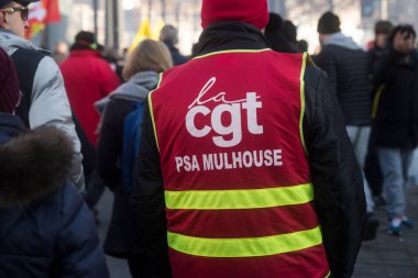Mulhouse - France - 7 February 2023 - Portrait on back view of  people protesting in the street with a red CGT syndicate jacket 