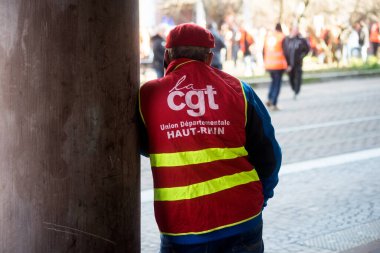Mulhouse - France - 7 February 2023 - Portrait on back view of  people protesting in the street with a red CGT syndicate jacket 