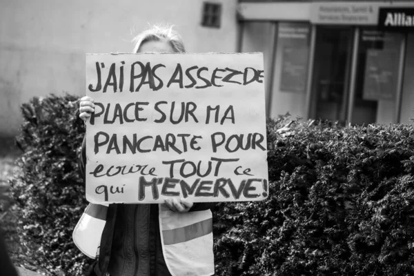 woman protesting in the streetwith placard in french : j\'ai pas assez de place sur ma pancarte pour crire tout ce qui m\'enerve , in english, I don\'t have enough space on my sign to write everything