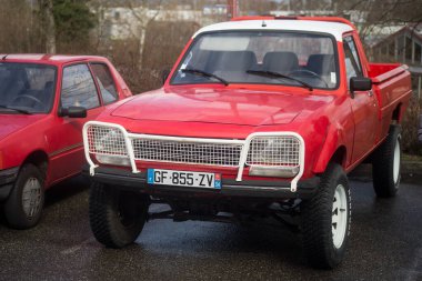 Mulhouse - Fransa - 12 Mart 2023 - Yağmurlu bir günde sokağa park edilmiş kırmızı Peugeot 204 'ün ön görüntüsü 