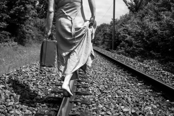 Demiryollarında Elinde Siyah Beyaz Bir Bavulla Yürüyen Bir Kadın — Stok fotoğraf