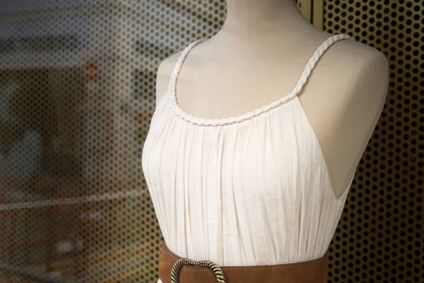 Closeup of white vintage dress on mannequin in a fashion store showroom