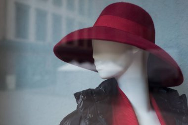 Moda mağazasının vitrininde kırmızı şapkanın üzerine yakın plan.