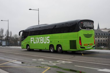 Mulhouse - Fransa - 7 Mart 2024 - Caddedeki tren istasyonunun önüne park etmiş yeşil otobüsün profil görüntüsü 