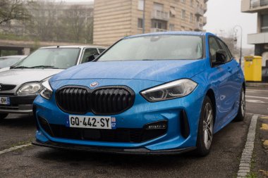 Mulhouse - Fransa - 31 Mart 2024 - Caddeye park edilmiş mavi BMW M1 serisinin ön görüntüsü