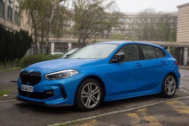 Mulhouse - Fransa - 31 Mart 2024 - Caddeye park edilmiş mavi BMW M1 serisinin profil görüntüsü